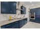 Sleek kitchen with navy cabinets, marble countertops, and a built-in oven at 34150 W Corleone Dr, Maricopa, AZ 85138