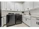 Bright laundry room with white cabinets and modern appliances at 34150 W Corleone Dr, Maricopa, AZ 85138