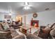 Living room with hardwood floors, brown sofas, and a decorative fireplace at 4340 E Silverbell Rd, San Tan Valley, AZ 85143