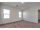 Bright and airy bedroom with neutral carpeting and two large windows at 4718 N 193Rd Dr, Litchfield Park, AZ 85340