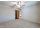 Well-lit bedroom featuring a double door closet and carpet flooring at 4805 W Saguaro Park Ln, Glendale, AZ 85310