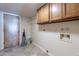 Laundry room with wooden cabinets and tiled floor at 4805 W Saguaro Park Ln, Glendale, AZ 85310