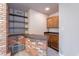 Wet bar with brick facing, wood cabinets, and granite countertop at 4805 W Saguaro Park Ln, Glendale, AZ 85310