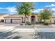 Tan, one-story house with a two-car garage and arched entryway at 6429 E Everett Dr, Scottsdale, AZ 85254