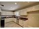 Well-lit kitchen with white cabinets, stainless steel appliances, and dark countertops at 701 W Cambridge Ave, Phoenix, AZ 85007