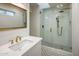 Modern bathroom with a glass shower, white tile, and gold fixtures at 8614 E Appaloosa Trl, Scottsdale, AZ 85258