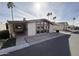 Tan single-wide manufactured home with carport, palm trees, and driveway at 9302 E Broadway Rd # 24, Mesa, AZ 85208