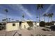 Tan mobile home with covered patio, satellite dish, and palm trees at 9302 E Broadway Rd # 24, Mesa, AZ 85208