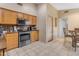 Kitchen with stainless steel appliances and wood cabinets, offering access to other areas at 10387 W Runion Dr, Peoria, AZ 85382