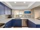 Modern kitchen with blue cabinets and quartz countertops at 10714 W Saratoga Cir, Sun City, AZ 85351