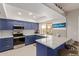 Modern kitchen with blue cabinets, quartz countertops, and stainless steel appliances at 10714 W Saratoga Cir, Sun City, AZ 85351