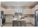 Modern kitchen with white cabinets, island, and stainless steel appliances at 1080 S 151St Ln, Goodyear, AZ 85338