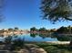 Serene community lake with a walking path and lush vegetation at 10949 W Sierra Pinta Dr, Peoria, AZ 85373