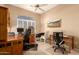 Bright home office features built-in wood desk and two executive chairs at 10949 W Sierra Pinta Dr, Peoria, AZ 85373