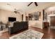 Bright living room with hardwood floors, ceiling fan, and view into kitchen at 10949 W Sierra Pinta Dr, Peoria, AZ 85373