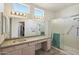 Bathroom with vanity, large mirror, and walk-in shower at 14812 W Las Brizas Ln, Sun City West, AZ 85375