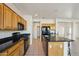 Kitchen with granite island, wood cabinets, and a view to backyard at 14812 W Las Brizas Ln, Sun City West, AZ 85375