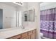 Bathroom with double vanity and patterned shower curtain at 15857 W Yavapai St, Goodyear, AZ 85338