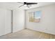 Simple bedroom with ceiling fan and window coverings at 15857 W Yavapai St, Goodyear, AZ 85338