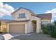 Two-story house with tan exterior and a two-car garage at 15857 W Yavapai St, Goodyear, AZ 85338