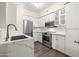 Modern kitchen features stainless steel appliances, white cabinetry, and quartz countertops at 1701 E Colter St # 223, Phoenix, AZ 85016