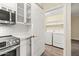 Convenient laundry closet off the kitchen with washer, dryer, and shelving for storage at 1701 E Colter St # 223, Phoenix, AZ 85016