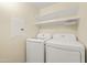 Bright laundry room with washer, dryer, and shelving at 1701 E Colter St # 223, Phoenix, AZ 85016