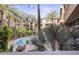 A serene pool and patio area framed by lush palm trees at 1701 E Colter St # 223, Phoenix, AZ 85016