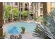 Community pool surrounded by mature trees and manicured landscaping at 1701 E Colter St # 223, Phoenix, AZ 85016