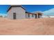 Rear view of a gray home featuring a covered back patio and desert landscaping at 17017 W Baker Dr, Surprise, AZ 85387