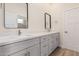 Bathroom featuring double sinks, quartz countertops, modern fixtures, and wood-look tile flooring at 17017 W Baker Dr, Surprise, AZ 85387