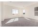 Bright bedroom features neutral carpet, recessed lighting, and views of the surrounding desert landscape at 17017 W Baker Dr, Surprise, AZ 85387