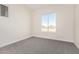 Vacant bedroom featuring plush gray carpet and a bright window at 17017 W Baker Dr, Surprise, AZ 85387