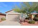 One-story house with tan exterior, two-car garage, and landscaping at 1828 W Owens Way, Anthem, AZ 85086