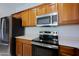 Stainless steel appliances and wood cabinets in kitchen at 1828 W Owens Way, Anthem, AZ 85086