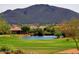 Serene pond view with surrounding homes and mountains at 1828 W Owens Way, Anthem, AZ 85086