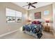 Bedroom with a queen bed, ceiling fan, and window at 18311 W East Wind Ave, Goodyear, AZ 85338