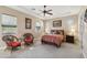 Well-lit bedroom with two wicker chairs and a queen bed at 18311 W East Wind Ave, Goodyear, AZ 85338