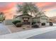 House with mature tree and desert landscaping at 18311 W East Wind Ave, Goodyear, AZ 85338