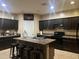 Kitchen with dark cabinets, an island, and stainless steel appliances at 18656 W Raymond St, Goodyear, AZ 85338