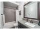 Modern bathroom with gray tile, a large mirror, and a spacious vanity at 19447 S 209Th Pl, Queen Creek, AZ 85142