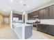 Spacious kitchen with an island, white quartz countertops, and dark brown cabinetry at 19583 W Cheery Lynn Rd, Buckeye, AZ 85396