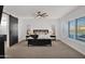 Spacious bedroom with barn door, ceiling fan, and large windows at 19780 E Ivy Ln, Queen Creek, AZ 85142