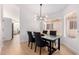 Bright dining area with modern light fixture, black table, and gray chairs at 2018 E Glenhaven Dr, Phoenix, AZ 85048