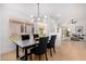 Modern dining area with black table, gray chairs, and a view of the backyard at 2018 E Glenhaven Dr, Phoenix, AZ 85048