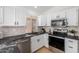 Modern kitchen with white cabinets, dark countertops, and stainless steel appliances at 2018 E Glenhaven Dr, Phoenix, AZ 85048