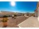 Landscaped backyard featuring stone and desert garden, paver walkway, with covered outdoor kitchen at 22901 E Quintero Rd, Queen Creek, AZ 85142