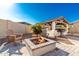 Beautiful backyard with a built-in outdoor kitchen, fire pit, desert landscaping and stylish patio at 22901 E Quintero Rd, Queen Creek, AZ 85142