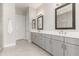 Bathroom featuring double sink vanity, modern lighting, framed mirrors, and gray cabinets at 22901 E Quintero Rd, Queen Creek, AZ 85142