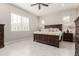 Spacious primary bedroom featuring a large wooden bed frame, bedside tables, and tile flooring at 22901 E Quintero Rd, Queen Creek, AZ 85142